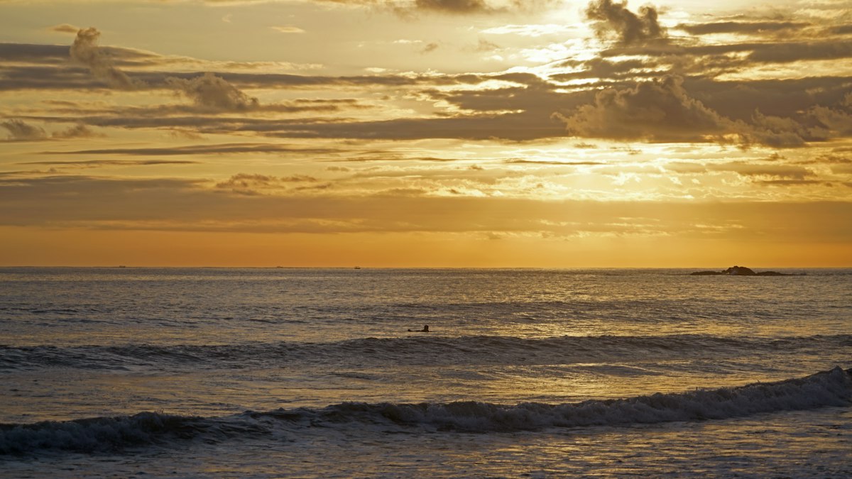 Surfing at sunset · illustrative photo